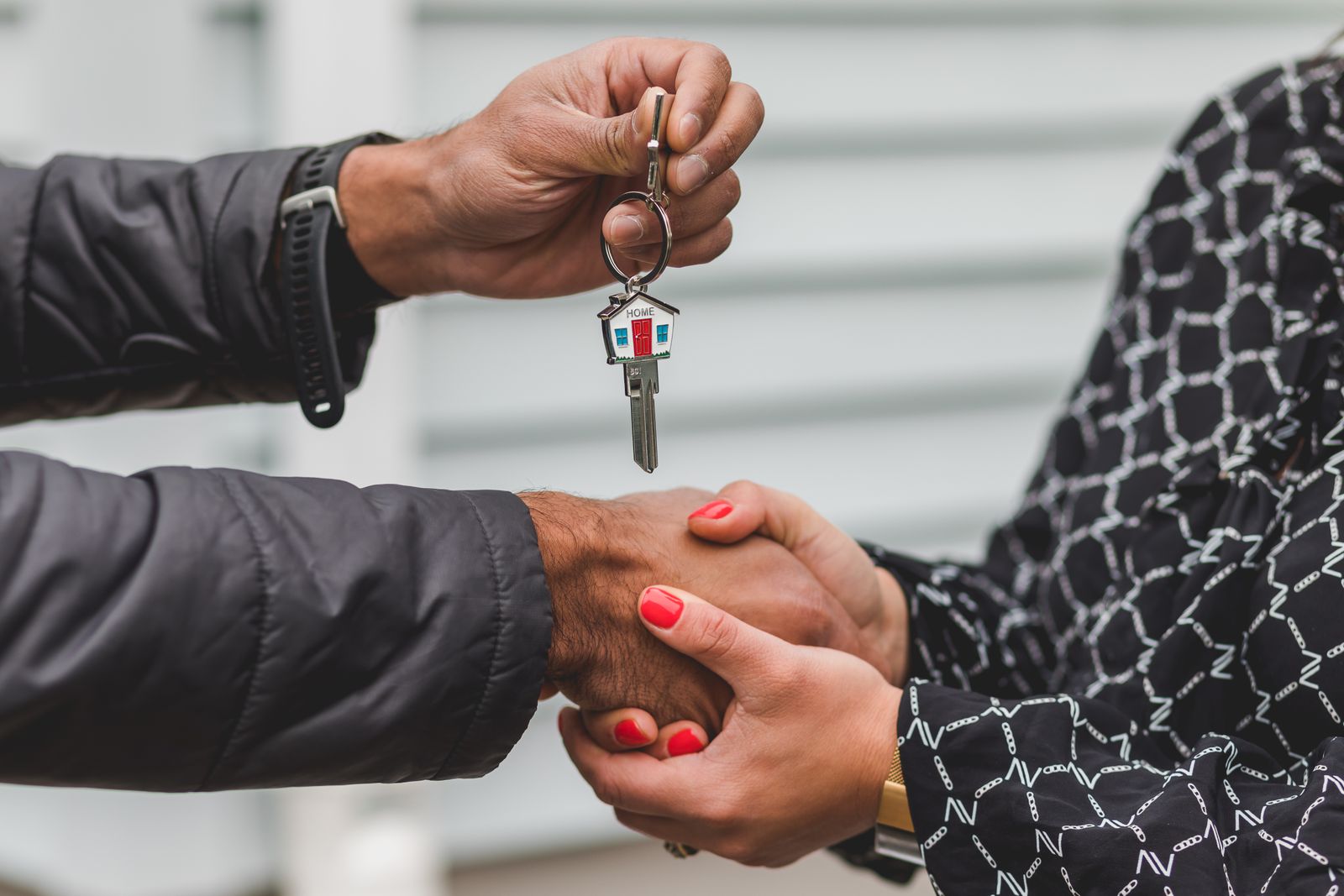 African American couple shaking hands and receiving the keys to their new home