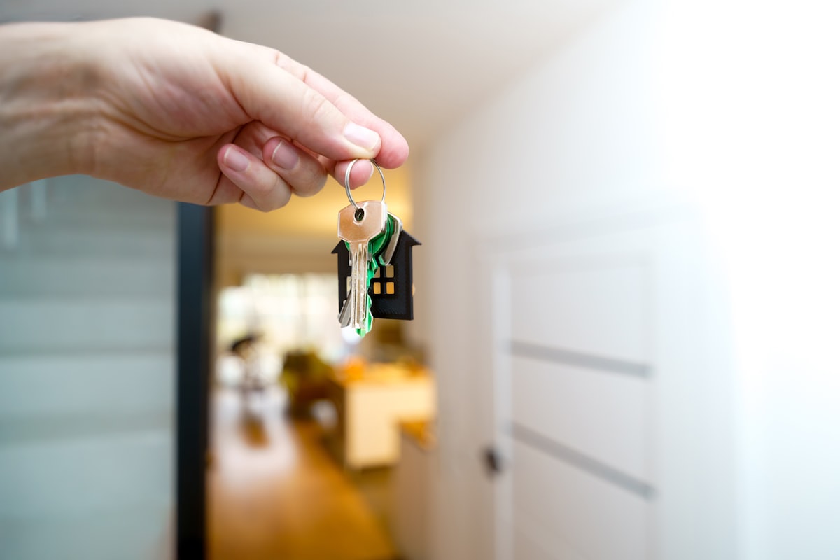 Hand holding the keys to a new home in the doorway